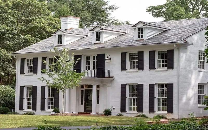 White two-story Carolina home with black shutters and a green lawn